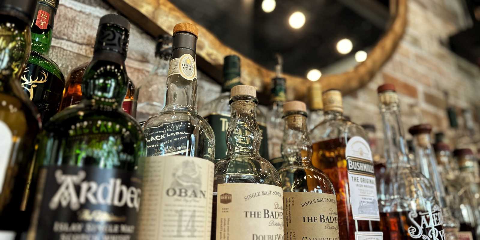 bottles of liquor on bar with mirror